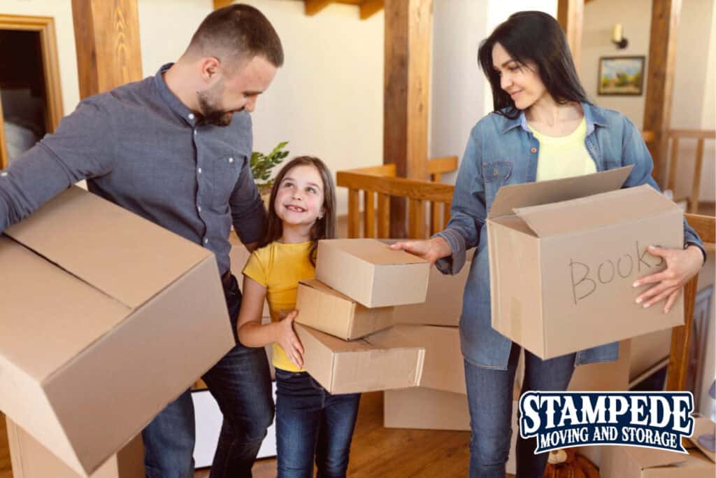 Family carrying moving boxes at home.