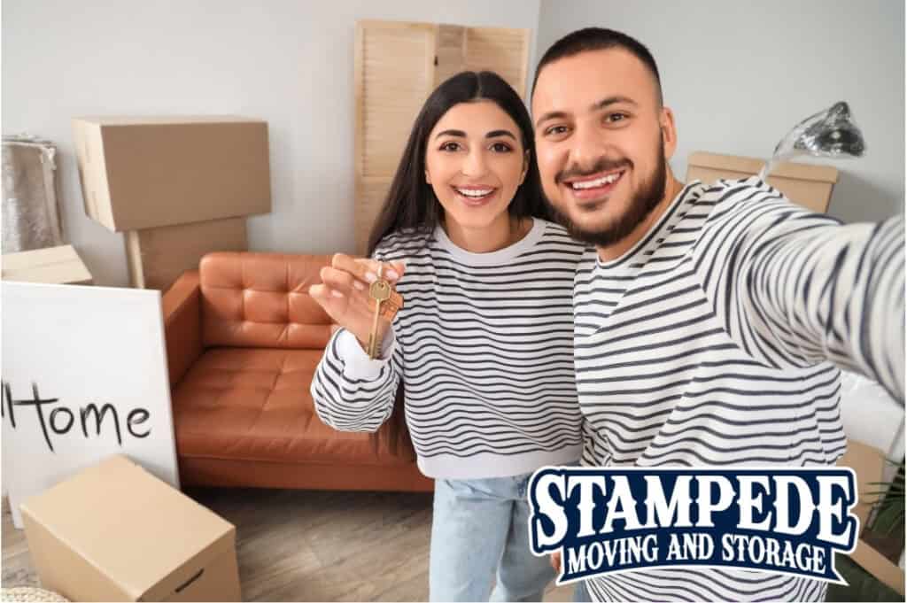 Couple holding keys in new home with boxes.