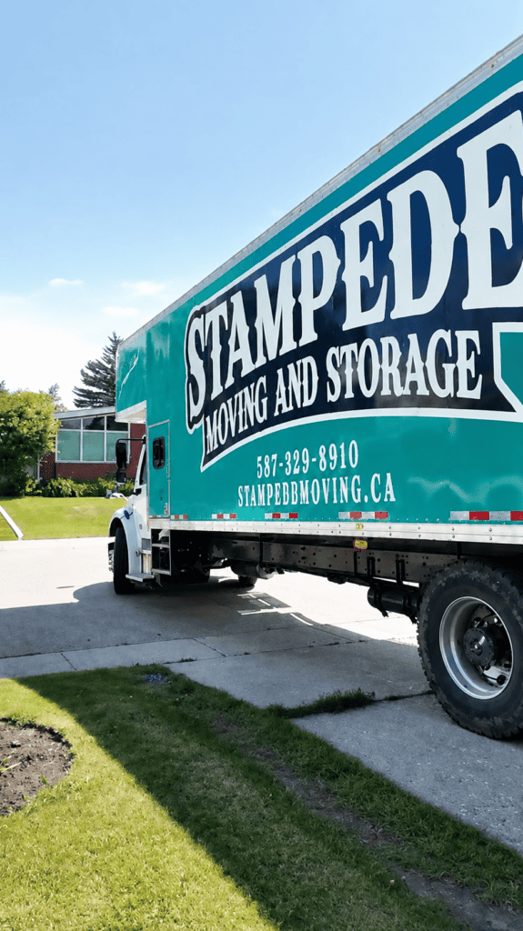 Stampede Moving & Storage truck arrives at a Calgary property, ready to provide reliable residential moving and transportation services.