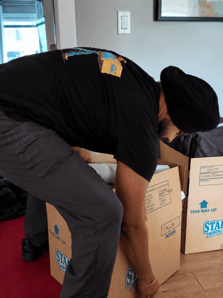 Stampede Moving & Storage professional carefully handles packed boxes during a residential move, keeping belongings organized for transport.